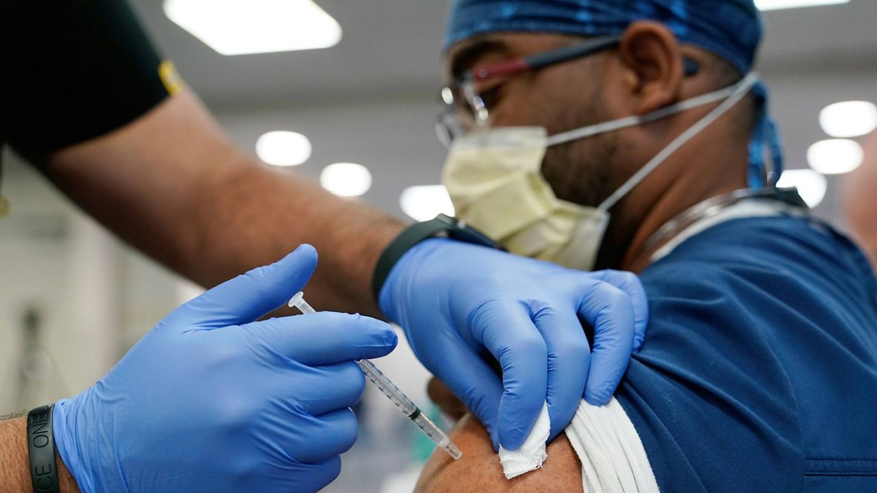 A health care worker receives a Pfizer COVID-19 booster shot at Jackson Memorial Hospital in Miami on Oct. 5. (AP Photo/Lynne Sladky)