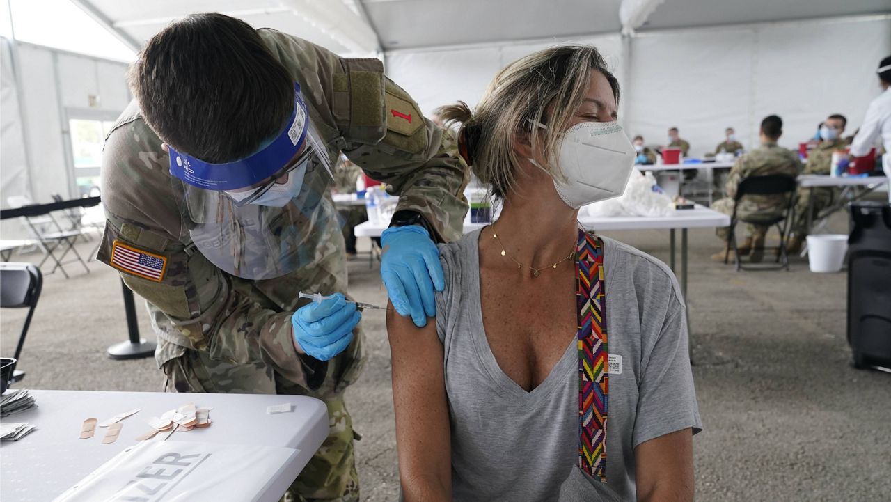 Liana Fonseca looks away as she receives the Pfizer COVID-19 vaccine on Tuesday in Miami. (AP Photo/Marta Lavandier)