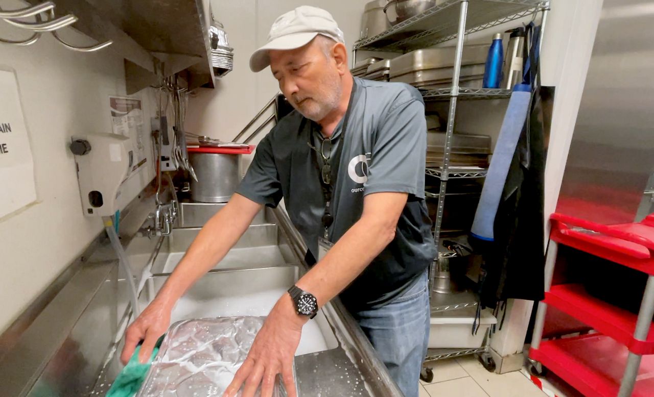 Volunteer Phil Edwards washes dishes at OurCalling. (Spectrum News 1/Stacy Rickard)