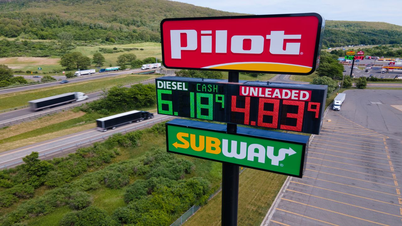 Trucks and cars drive by a Pilot Travel Center sign displaying fuel prices in Bath, New York, on Monday, June 20, 2022.