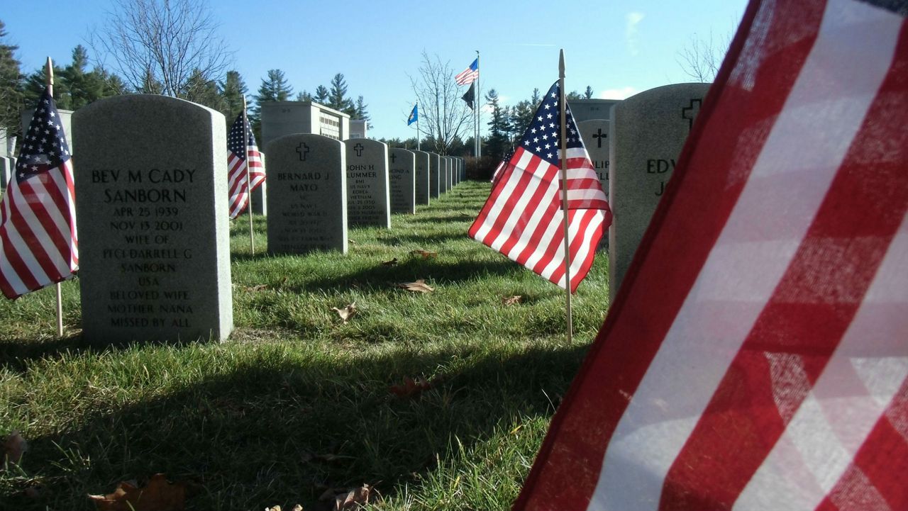Flags situated next to graves at an unnamed cemetery. (Pixabay)