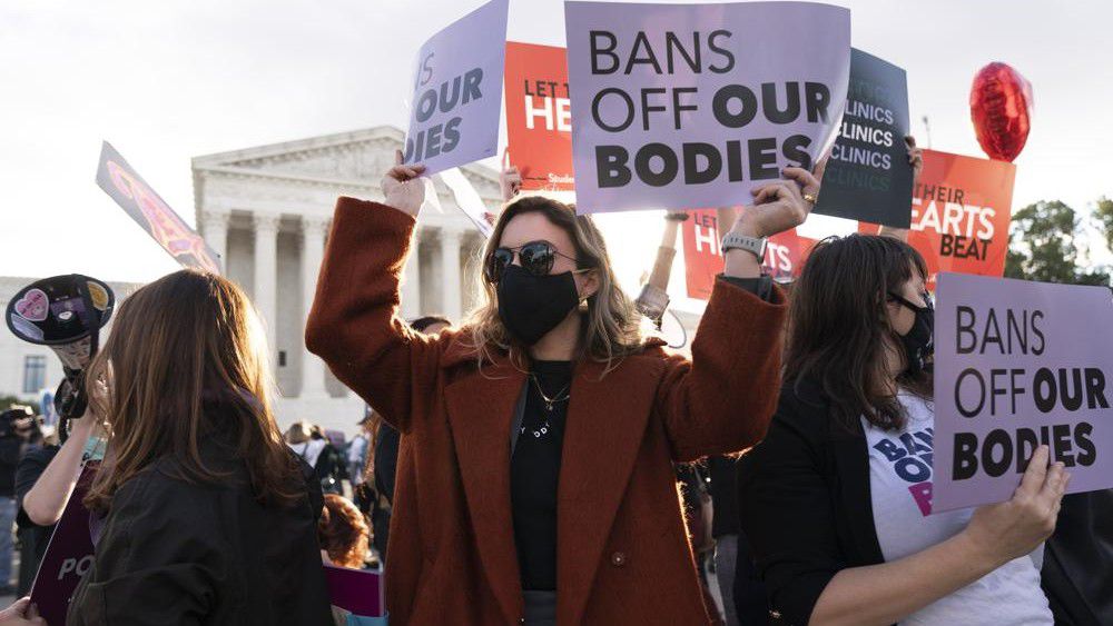 Emily Halvorson, center, of Washington, with Planned Parenthood, joins groups of abortion-rights and anti-abortion activists as they rally outside the Supreme Court, Monday, Nov. 1, 2021, as arguments are set to begin about abortion by the court, on Capitol Hill in Washington. (AP Photo/Jacquelyn Martin)