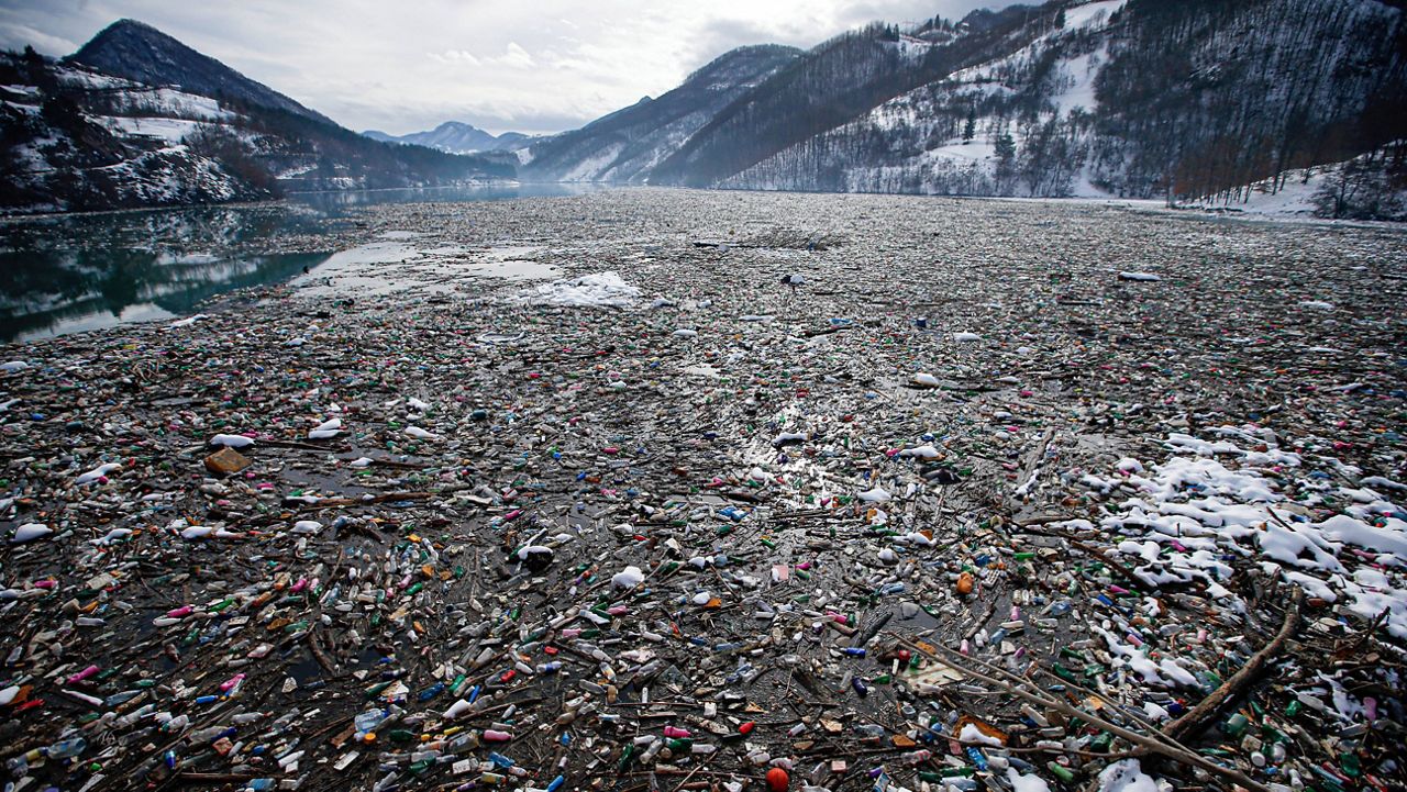 In this Jan. 22, 2021, file photo, plastic bottles and other garbage float in the Potpecko Lake near Priboj, Serbia. (AP Photo/Darko Vojinovic, File)