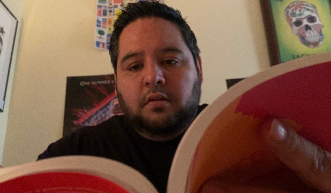 Rooster Martinez reads a book in his home office. (Spectrum News 1/Jose Arredondo)