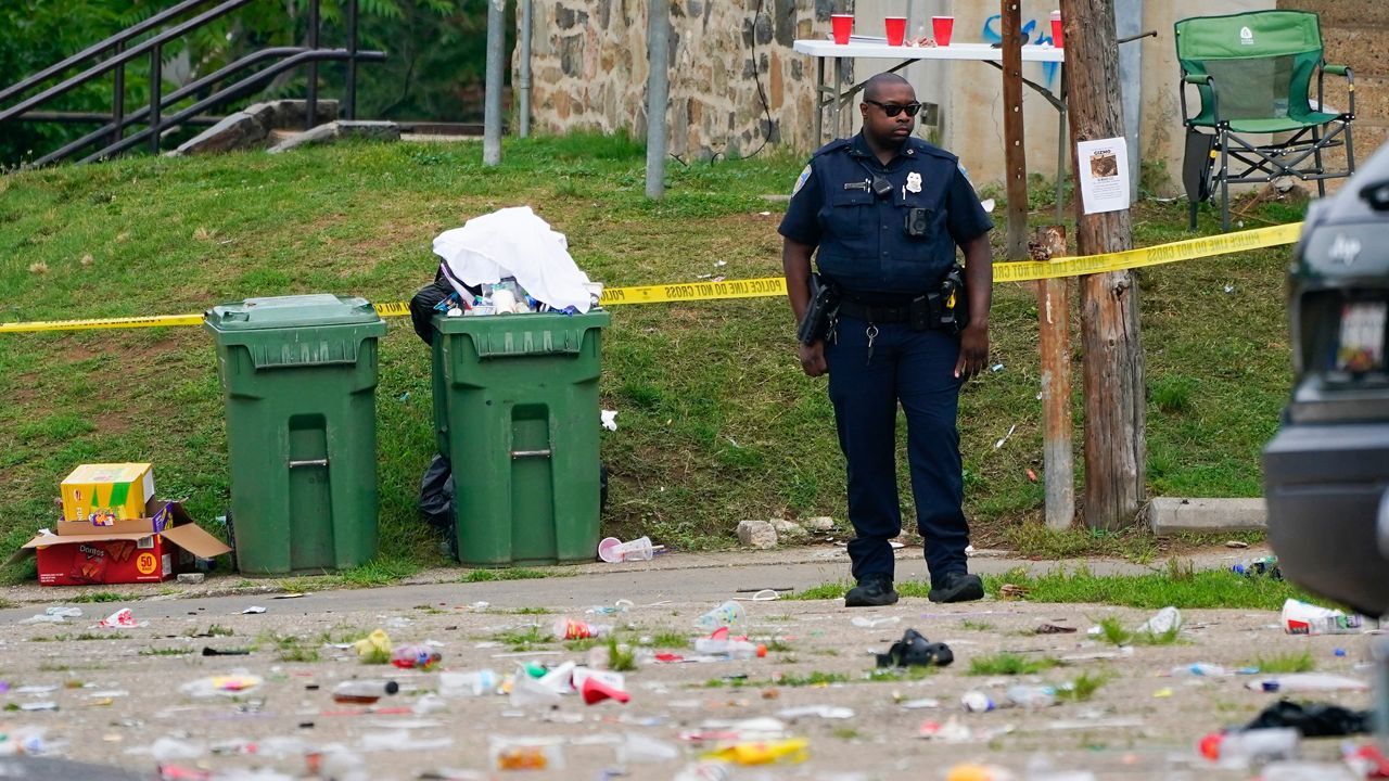 A police officer stands in the area of a mass shooting incident in the Southern District of Baltimore on Sunday, July 2, 2023.