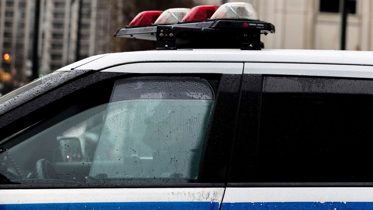 A police officer sits in a car near the Brooklyn Bridge on Friday, Dec. 16, 2022.