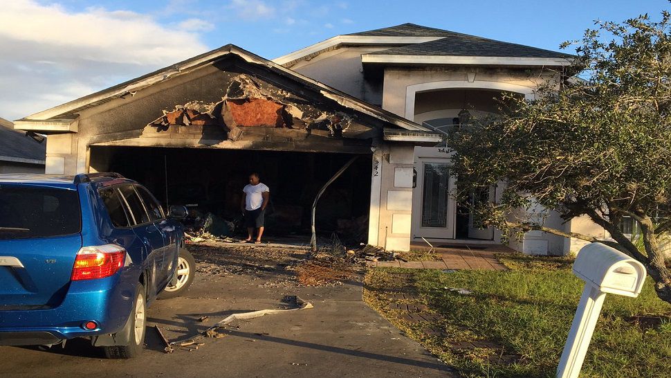 A fire tore through a Davenport home Thursday after lightning struck the garage during heavy storms. (Dalia Dangerfield/Spectrum Bay News 9)