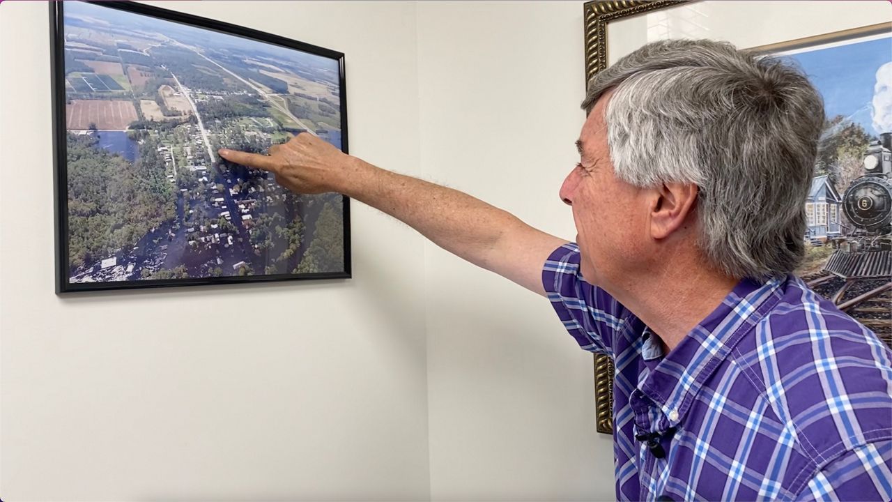 Mayor Jay Bender looks at a photo of Pollocksville after Hurricane Florence. (Spectrum News 1/Jenna Rae Gaertner)