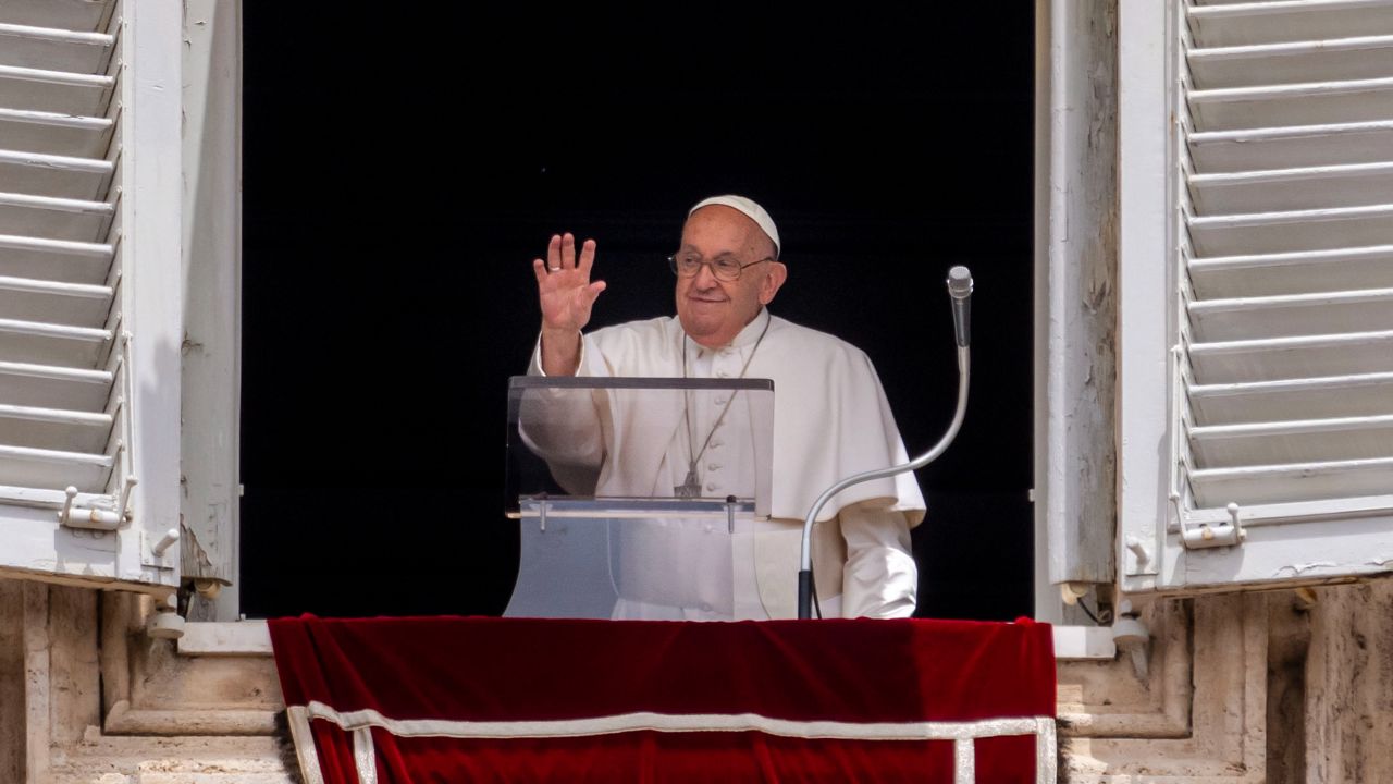 Pope Francis waves from his studio's window overlooking St. Peter's Square at the Vatican on Sunday, June 9, 2024, where the faithful gathered for the traditional Sunday's blessing at the end of the Angelus prayer. (AP Photo/Domenico Stinellis)