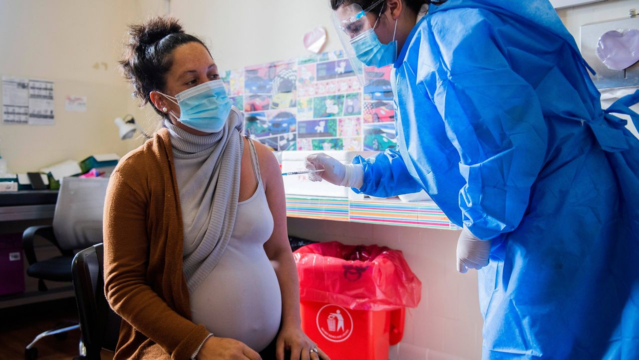 In this June 9, 2021, file photo, a nurse gives a shot of the Pfizer COVID-19 vaccine to a pregnant woman in Montevideo, Uruguay. (AP Photo/Matilde Campodonico, File)