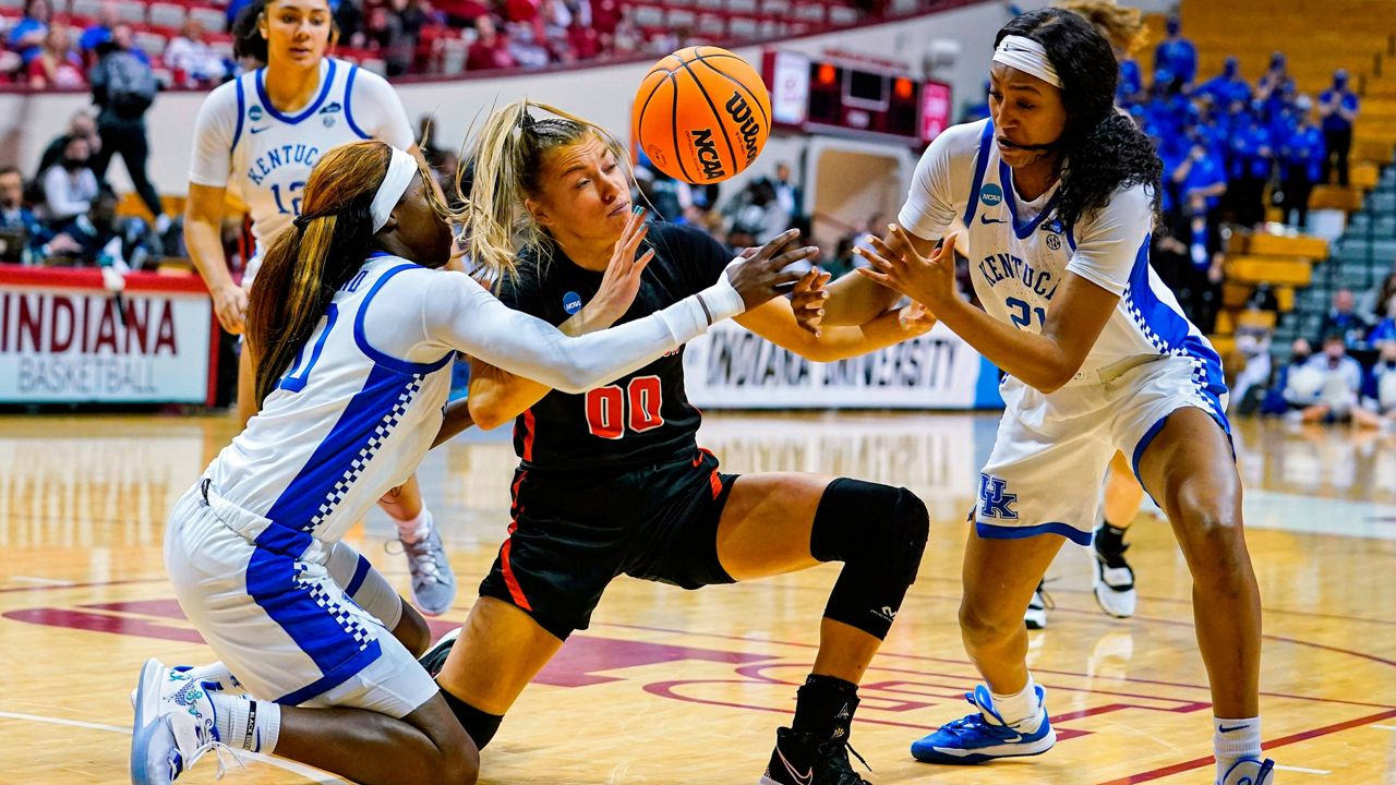 Princeton forward Ellie Mitchell (00), Kentucky guard Rhyne Howard (10) and forward Nyah Leveretter (21) fight for a loose ball in the first half of a college basketball game in the first round of the NCAA tournament in Bloomington, Ind., Saturday, March 19, 2022. (AP Photo/Michael Conroy)