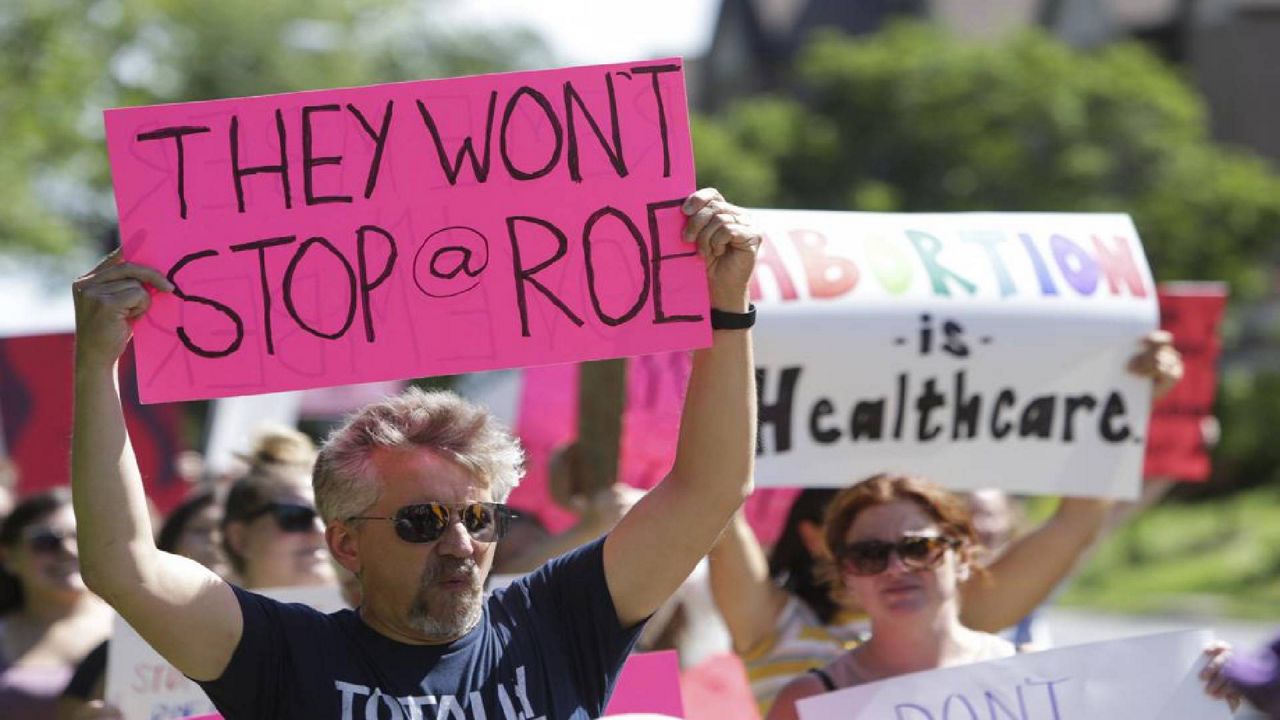  A man holds a sign as community members walk around Vander Veer Park during a march following the Supreme Court decision to overturn Roe v. Wade, June 26, 2022, in Davenport, Iowa. Democrats and their aligned groups raised more than $80 million in the week after the Supreme Court stripped away a woman’s constitutional right to have an abortion. The flood of cash offers one of the first tangible signs of how the ruling may energize voters. (Nikos Frazier/Quad City Times via AP)
