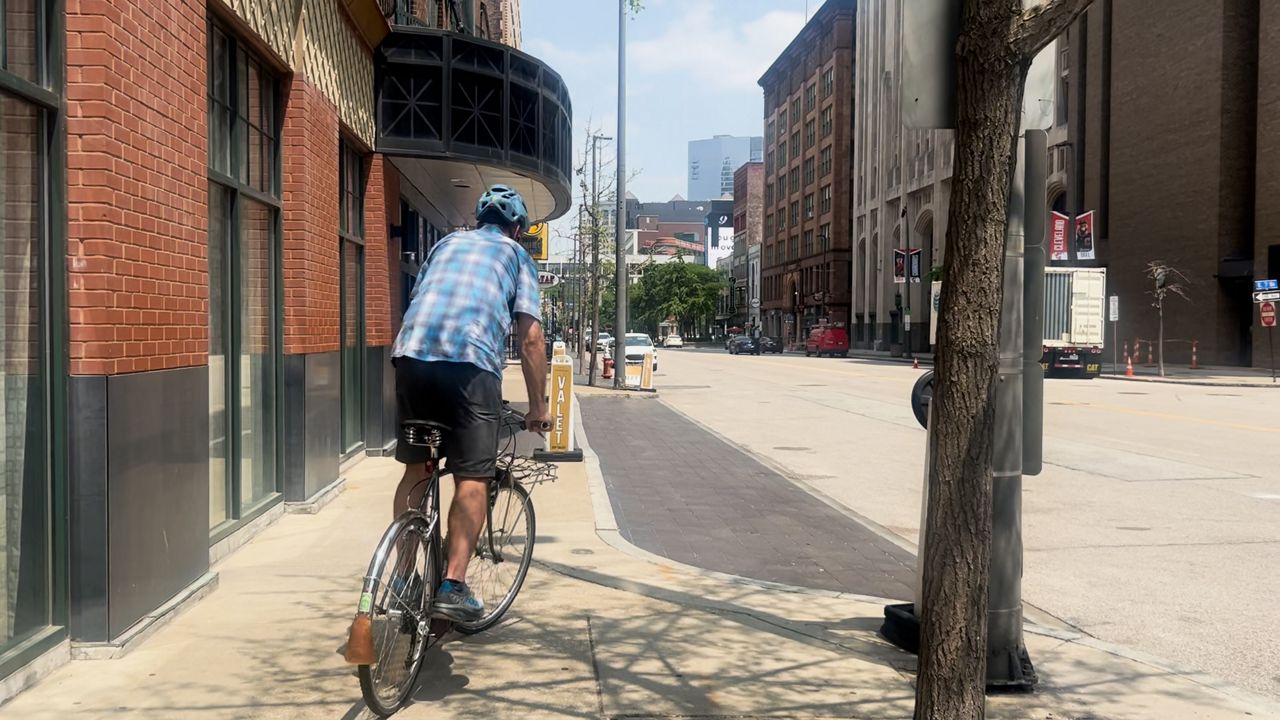 Jacob Kuhn biking on the sidewalk near where the new protected bike lanes witll be (Katie Priefer)