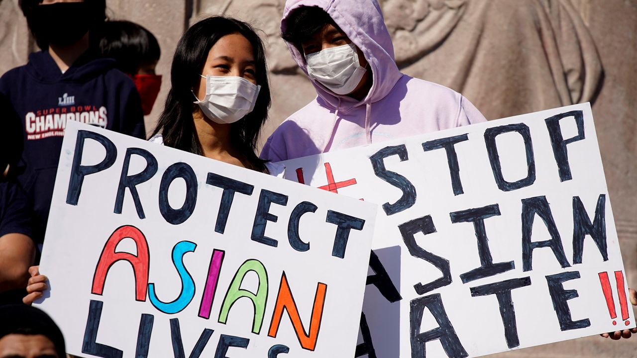 People hold signs as they attend a rally to support Stop Asian Hate at the Logan Square Monument in Chicago in March 2021. (AP Photo/Nam Y. Huh)