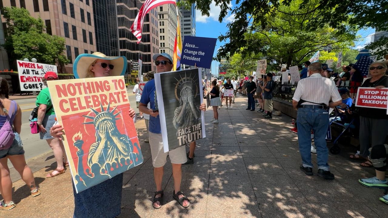 Protesters hold signs Friday.