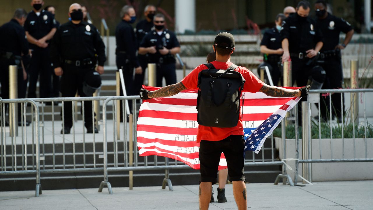 Stephen Chang of Los Angeles protests in front of police officers at Los Angeles Police Department headquarters