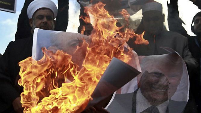 Palestinians burn poster of Israeli Prime Minister Benjamin Netanyahu and U.S. President Donald Trump, during a protest against the U.S. decision to recognize Jerusalem as Israel's capital, in Garza City Thursday, Dec. 7, 2017. (AP Photo/Khalil Hamra)