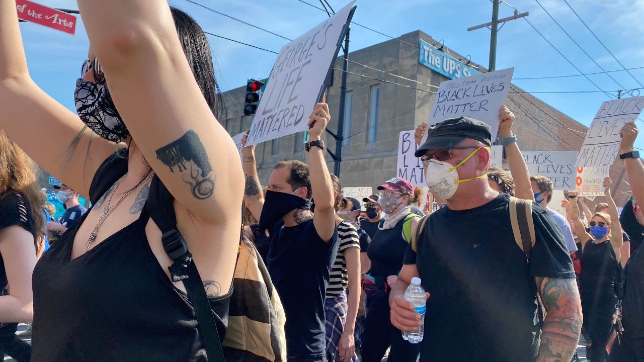 protesters march with signs