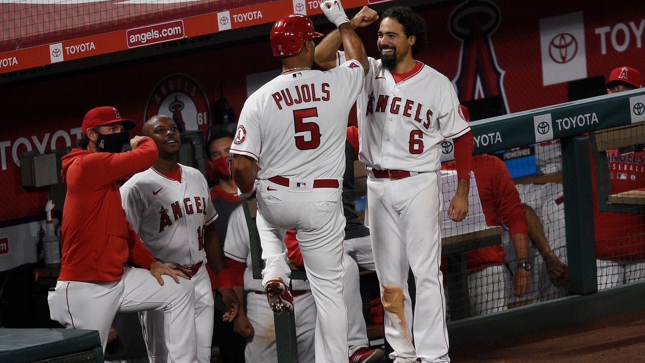 Los Angeles Angels' Albert Pujols (5) celebrates with Anthony Rendon while heading into the dugout after a solo home run during the fifth inning of the team's baseball game against the Seattle Mariners in Anaheim, Calif., Tuesday, July 28, 2020. (AP Photo/Kelvin Kuo)