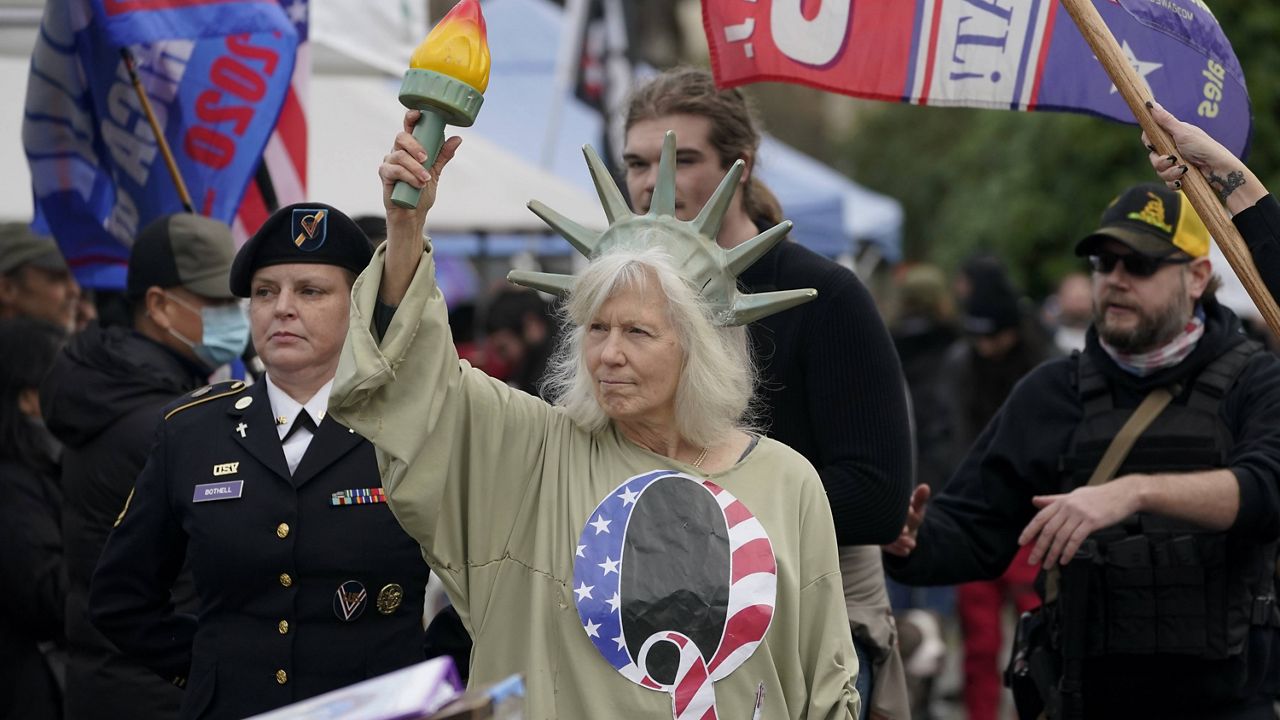 A woman dressed as the Statue of Liberty wears a shirt with the letter Q, referring to QAnon, during a protest at the Capitol in Olympia, Wash., on Jan. 6. (AP Photo/Ted S. Warren)