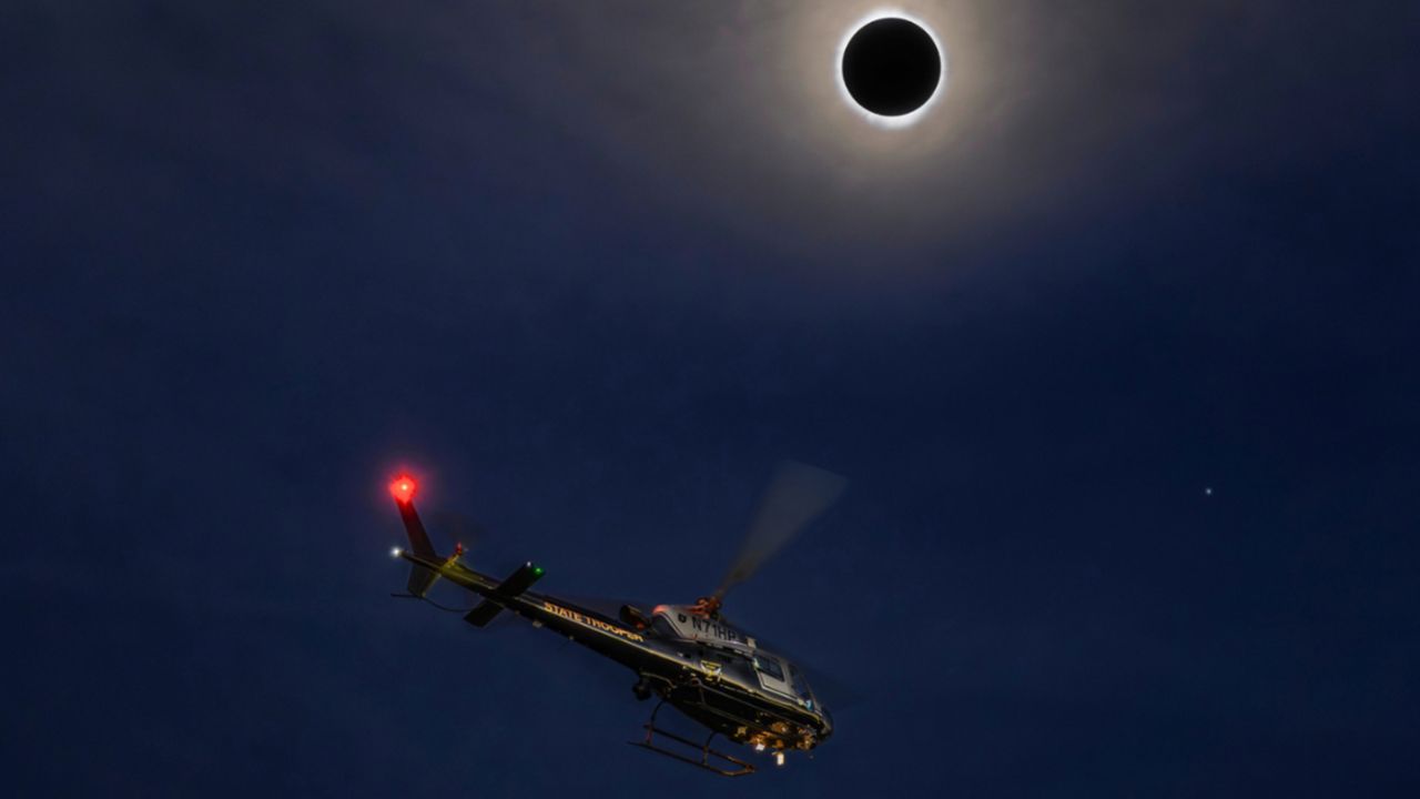 An Ohio State Highway Patrol helicopter flies during the total eclipse. 