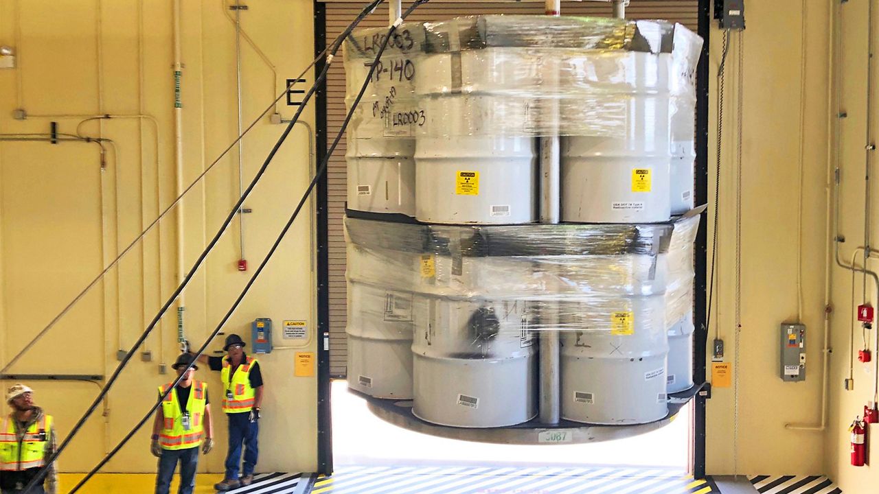 In this April 9, 2019, photo provided by Los Alamos National Laboratory, barrels of radioactive waste are loaded for transport to the Waste Isolation Pilot Plant, marking the first transuranic waste loading operations in five years at the Radioactive Assay Nondestructive Testing (RANT) facility in Los Alamos, N.M. A report from independent federal investigators Wednesday, July 19, 2023, said the price tag for cleaning up waste at the laboratory is rising and federal officials need to do more to track costs and progress of the $7 billion effort. (Nestor Trujillo/Los Alamos National Laboratory via AP)