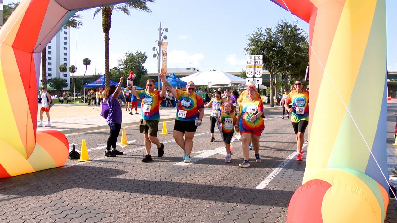 Runners celebrate crossing the finish line at the 9th annual CommUNITY Rainbow Run in Orlando.