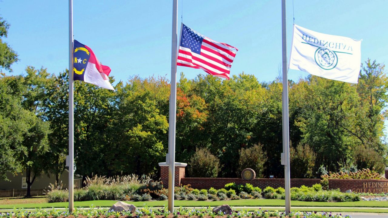 Flags fly at half-staff at the entrance to the Hedingham Golf Club in Raleigh, N.C., on Friday, Oct. 14, 2022, after a shooting in the community left five dead Thursday night. (AP Photo/Hannah Schoenbaum)