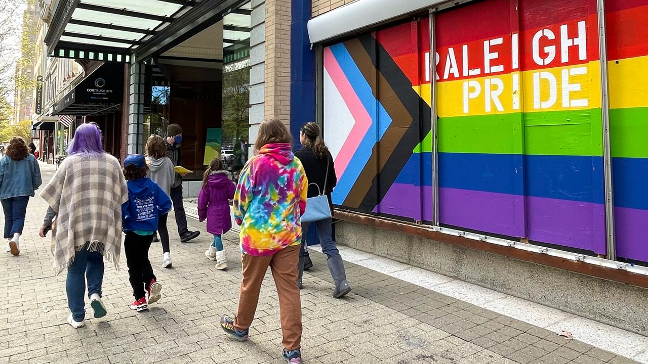 A family walks by an LGBTQ pride mural in downtown Raleigh, N.C., just a few blocks from the Legislative Building, on Nov. 16, 2022. (AP file photo/Hannah Schoenbaum)