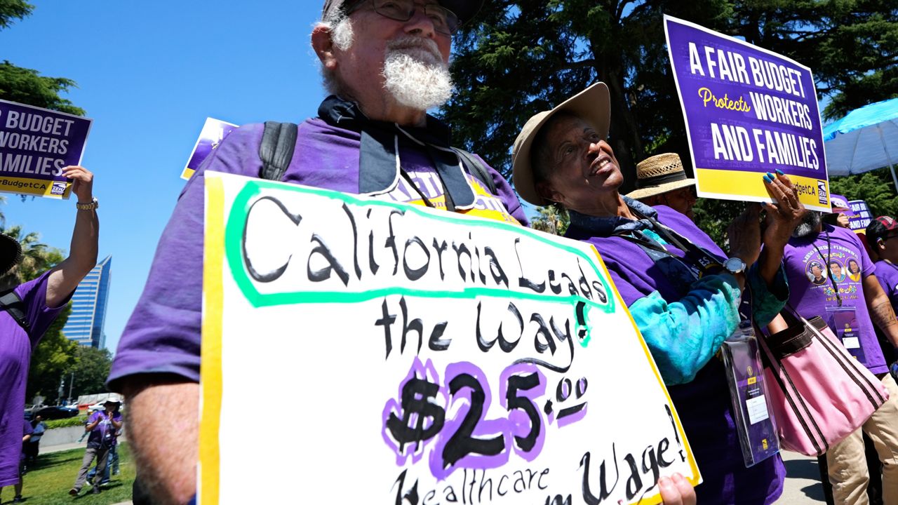 Retirees Ron Martin, left, and Willie Mae Hampton, right, join other supporters of the Service Employees International Union at a rally against proposed budget cuts to state provided social safety net programs, in Sacramento, Calif., June 11, 2024. (AP Photo/Rich Pedroncelli)