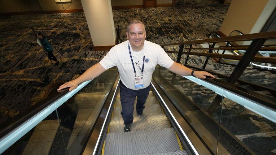 Student resource officer Tony Ramaeker, from Elkhorn, Neb., heads up an escalator while attending a convention, Tuesday, July 5, 2022, in Denver. (AP Photo/David Zalubowski)