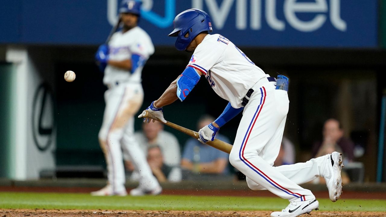 Texas Rangers' Bubba Thompson bunts for a single in the seventh inning of the team's baseball game against the Chicago White Sox, Thursday, Aug. 4, 2022, in Arlington, Texas.(AP Photo/Tony Gutierrez)