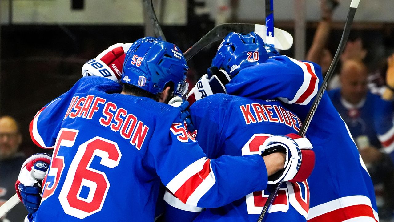 New York Rangers defenseman Erik Gustafsson (56), left wing Jimmy Vesey and others celebrate center Vincent Trocheck's goal against the Carolina Hurricanes during the first period in Game 1 of an NHL hockey Stanley Cup second-round playoff series, Sunday, May 5, 2024, in New York. (AP Photo/Julia Nikhinson)