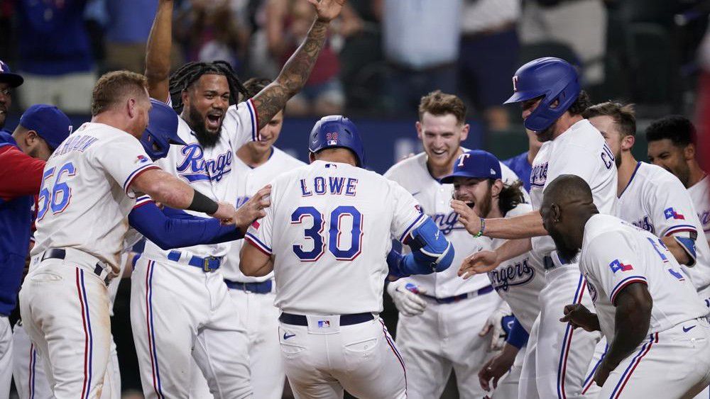 The Texas Rangers celebrate a walk-off, two-run home run hit by Nathaniel Lowe (30) during the 10th inning of the team's baseball game against the Los Angeles Angels, Wednesday, May 18, 2022, in Arlington, Texas. (AP Photo/Tony Gutierrez)