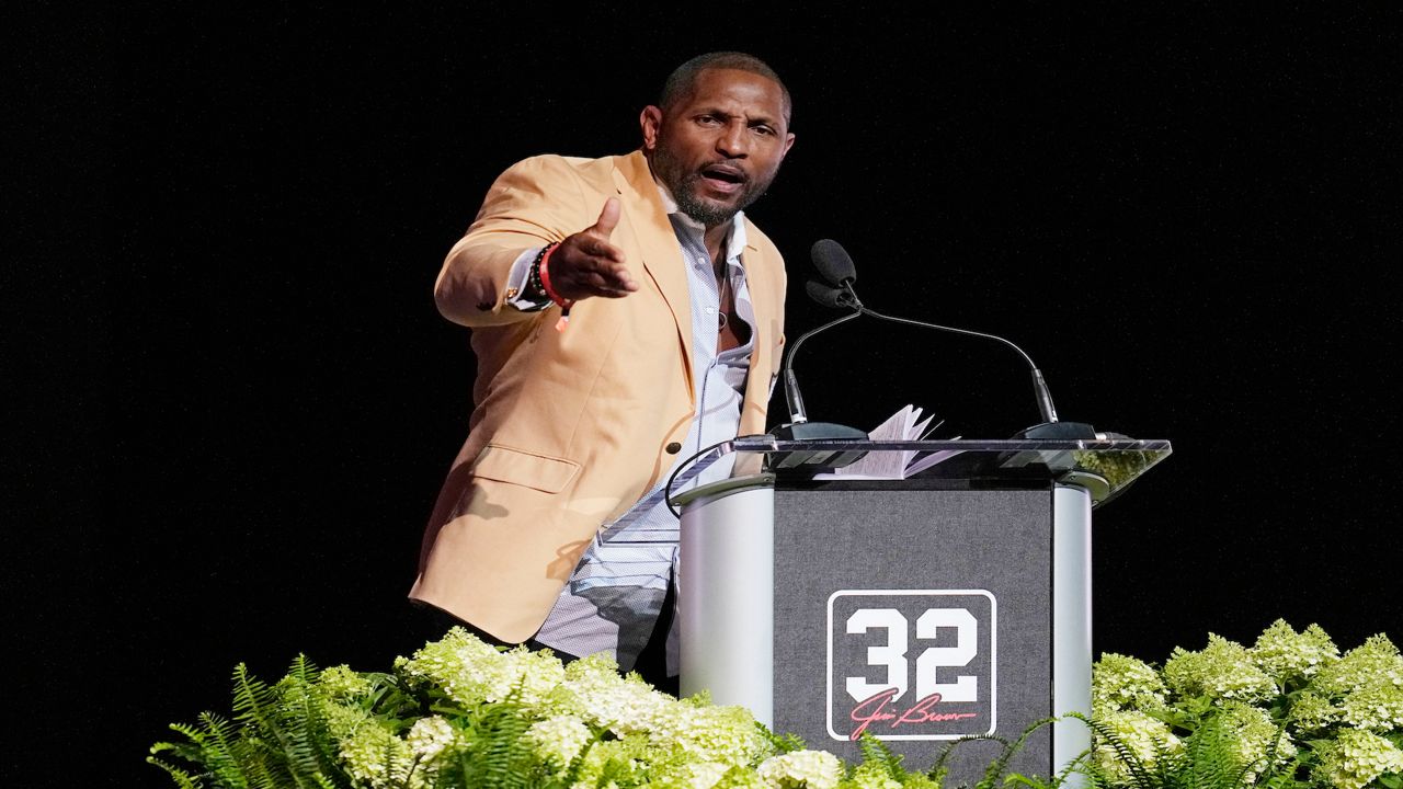 a man at a podium with his arm outstretched