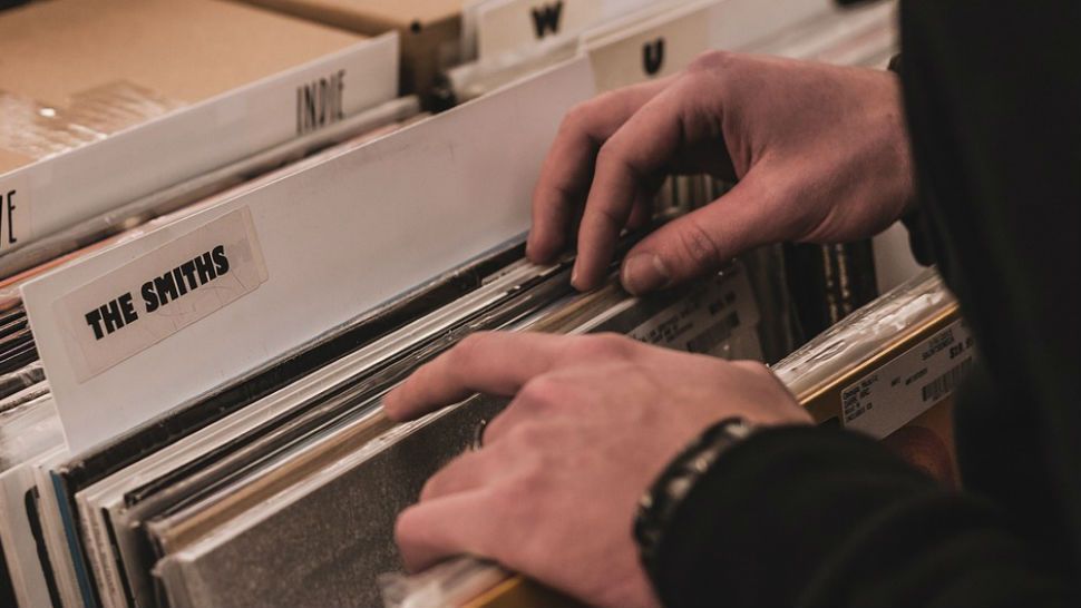Man digs through records at record store. 
