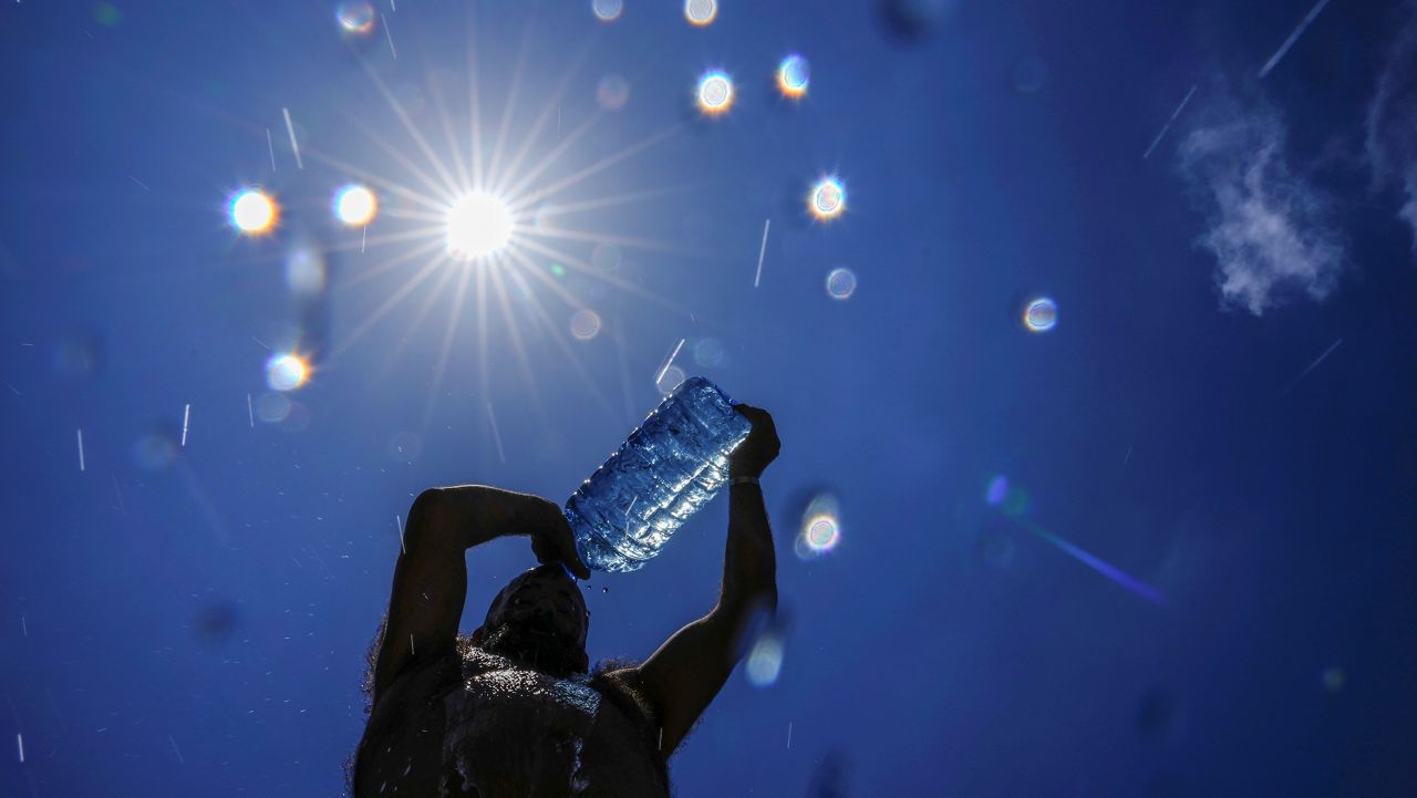 A man pours cold water onto his head to cool off on a sweltering hot day in the Mediterranean Sea in Beirut, Lebanon, Sunday, July 16, 2023. (AP Photo/Hassan Ammar)