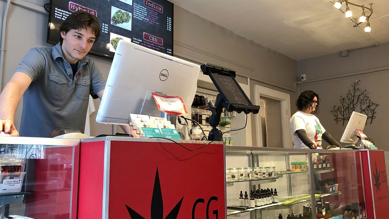 In this March 6, 2019, file photo, Korbin Osborn, left, works as a cannabis adviser at a medical marijuana dispensary in Santa Fe, New Mexico. (AP Photo/Morgan Lee)