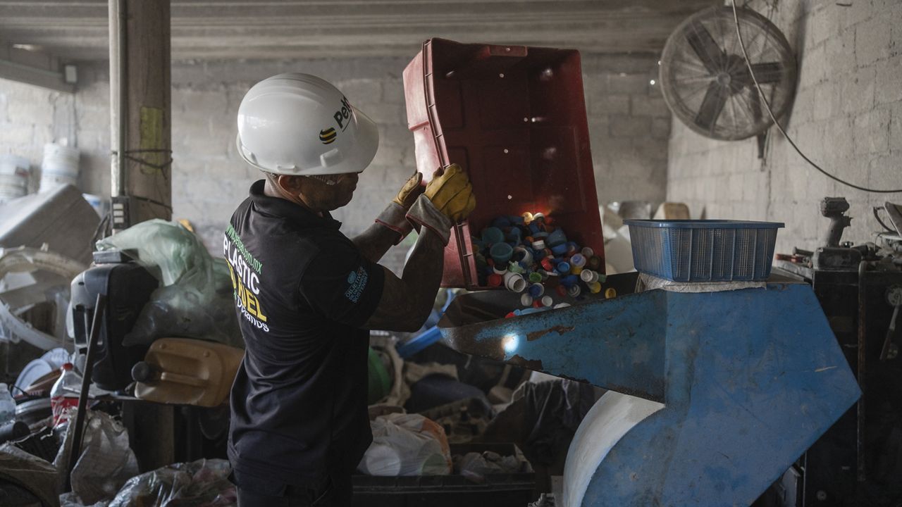 Jesus Cuevas, a Petgas technician, puts plastic caps into a shredding machine inside a recycling center in Boca del Rio, Veracruz, Mexico, Jan. 4, 2025. (AP Photo/Felix Marquez)