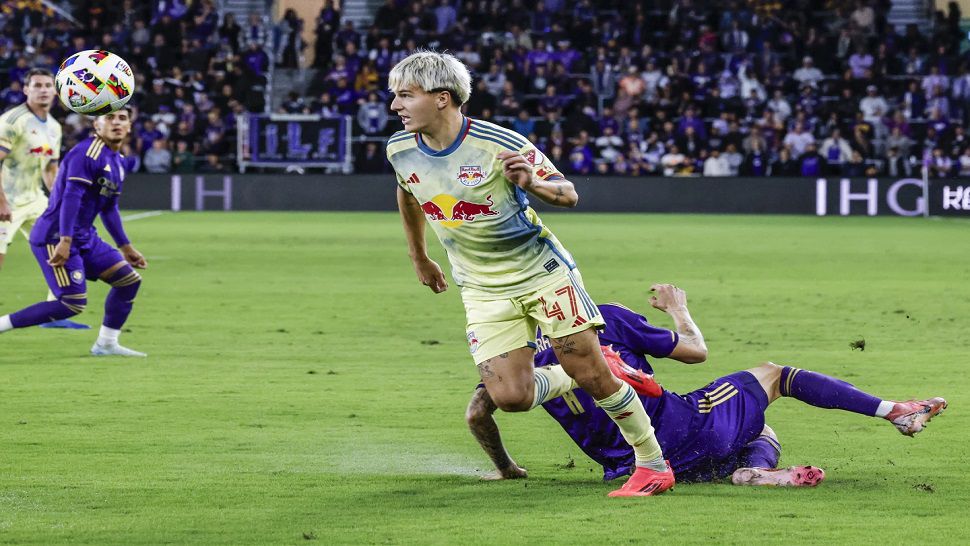 New York Red Bulls defender John Tolkin (47) gets ball away from Orlando City midfielder Dagur Dan Þórhallsson, right, during the first half of an MLS Eastern Conference final soccer match, Saturday, Nov. 30, 2024, in Orlando, Fla. (AP Photo/Kevin Kolczynski)