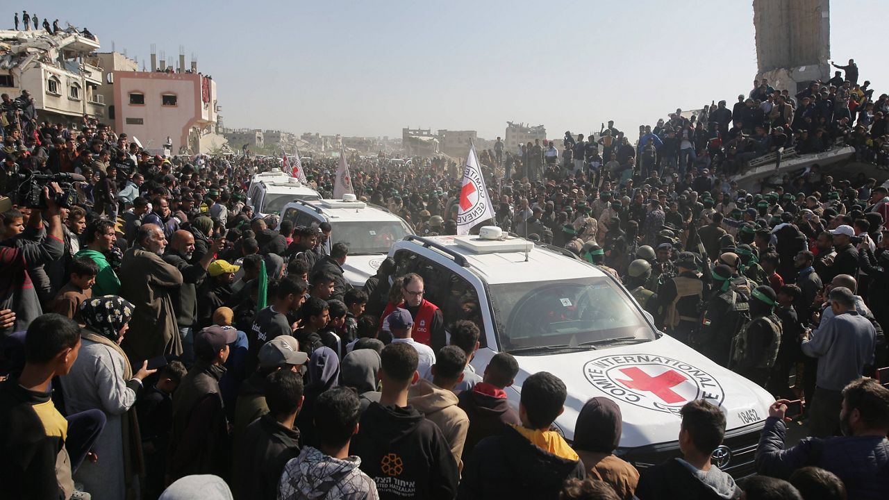 A crowd surrounds Red Cross cars as they arrive at the site for the handover of Thai and Israeli hostages in Khan Younis, southern Gaza Strip, Thursday Jan. 30, 2025.(AP Photo/Jehad Alshrafi)