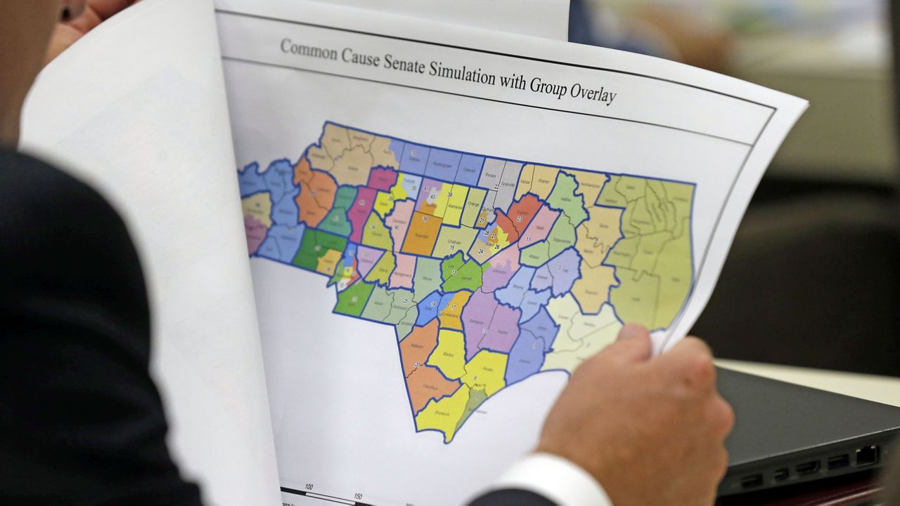  A North Carolina lawmaker studies a district map during a joint select committee meeting on redistricting, July 26, 2017, in Raleigh, N.C. North Carolina legislators are once again mapping the state’s congressional and General Assembly districts. The House and Senate redistricting committees scheduled hearings this week — the last one happening Wednesday, Sept. 27, 2023, in Raleigh — to receive public comment about the process of drawing district boundaries that would be used in the 2024 elections and for the remainder of the decade. (AP Photo/Gerry Broome, File)