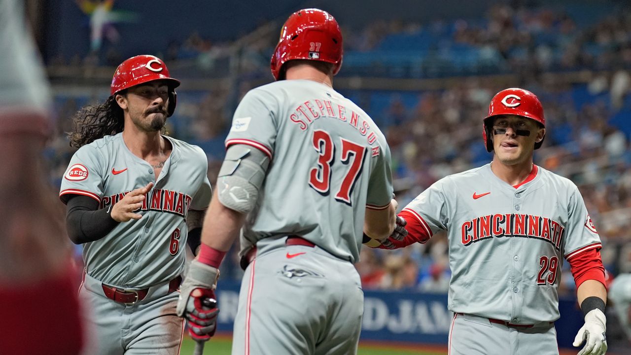 Cincinnati Reds' Jonathan India (6) and TJ Friedl (29) celebrate with on-deck batter Tyler Stephenson (37) after scoring on a two-run double by Jeimer Candelario off Tampa Bay Rays starting pitcher Shane Baz during the first inning of a baseball game Friday, July 26, 2024, in St. Petersburg, Fla. 