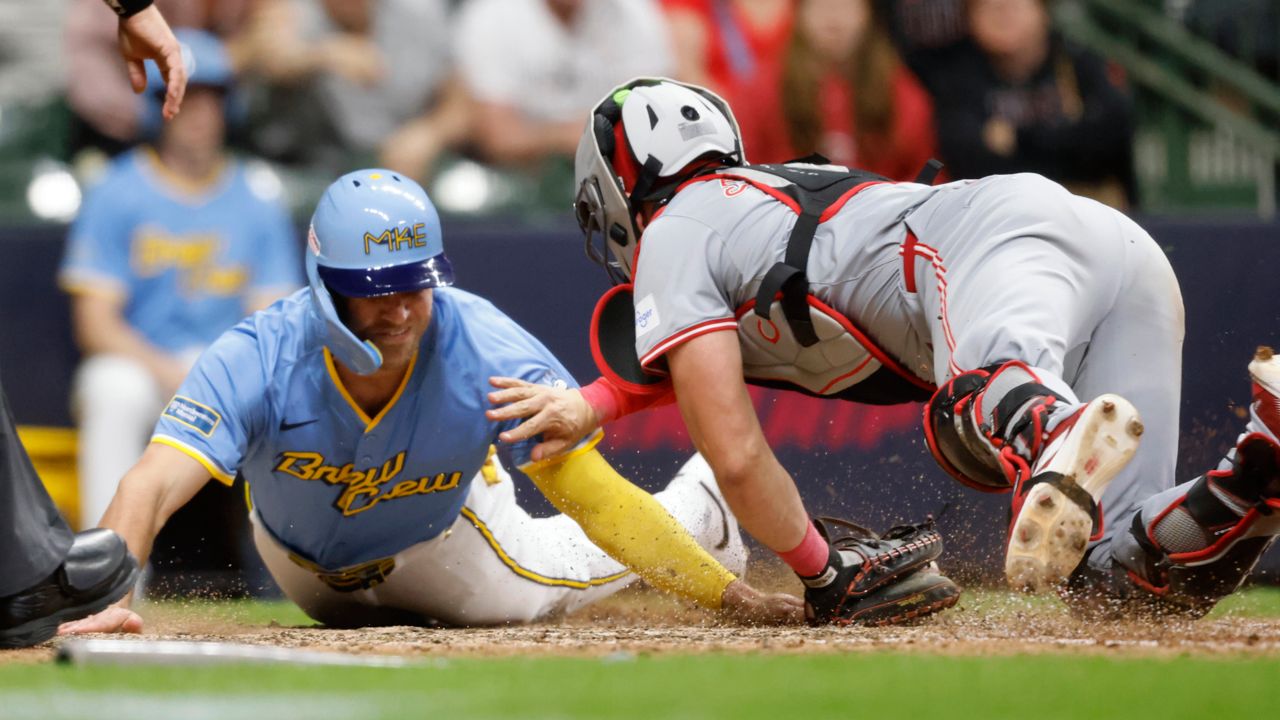 Cincinnati Reds' Tyler Stephenson, right, tags out Milwaukee Brewers' Jake Bauers during the ninth inning of a baseball game Friday, June 14, 2024, in Milwaukee. 