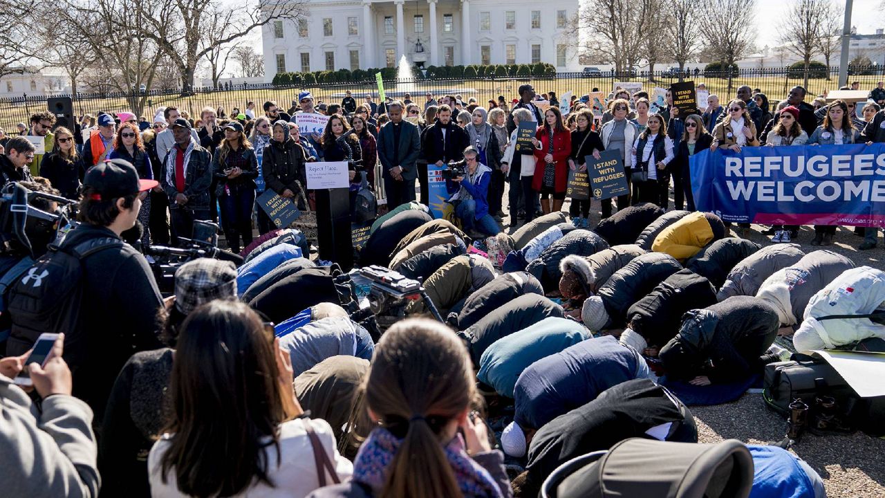 FILE - In this Jan. 27, 2018 file photo, Supporters surround a group who perform the Islamic midday prayer outside the White House in Washington during a rally on the one-year anniversary of the Trump Administration's first partial travel ban on citizens from seven Muslim majority countries. Organizations involved in refugee resettlement are awaiting President Joe Biden’s refugee admissions goal, set to be announced this month. (AP Photo/Andrew Harnik, File)