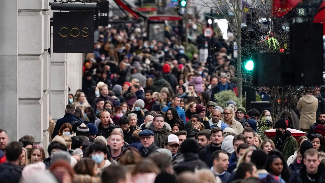 People, some wearing face masks, walk in Regent Street, in London, Sunday, Nov. 28, 2021. (AP Photo/Alberto Pezzali)