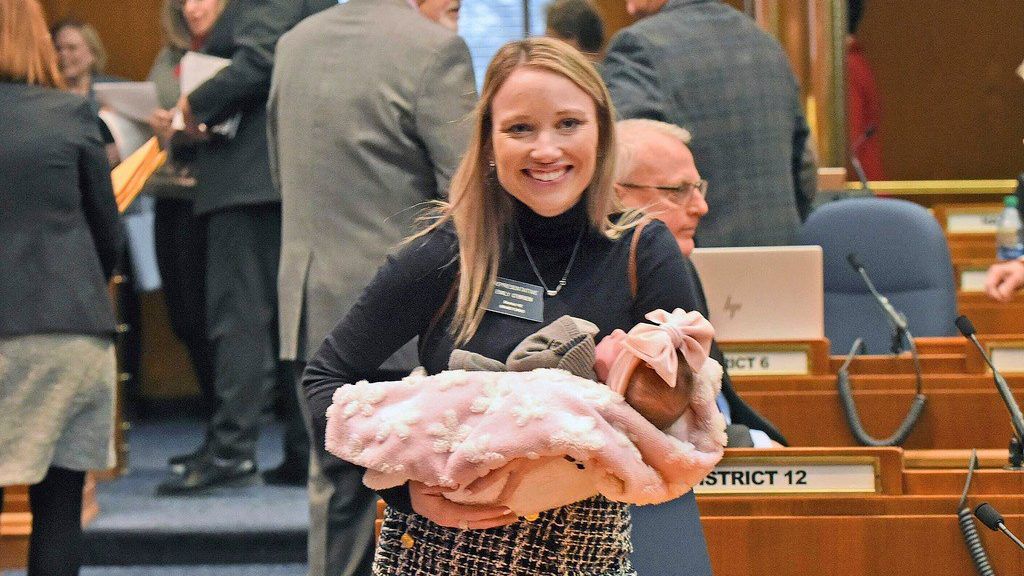 Rep. Emily O'Brien R-Grand Forks carries daughter Jolene Green, 3 weeks, into the House chamber, Dec. 6, 2022, in Bismarck, N.D. Last year, the state representative helped persuade her colleagues to approve $66 million in child care spending proposed by Gov. Doug Burnum, a Republican. (Tom Stromme/The Bismarck Tribune via AP)