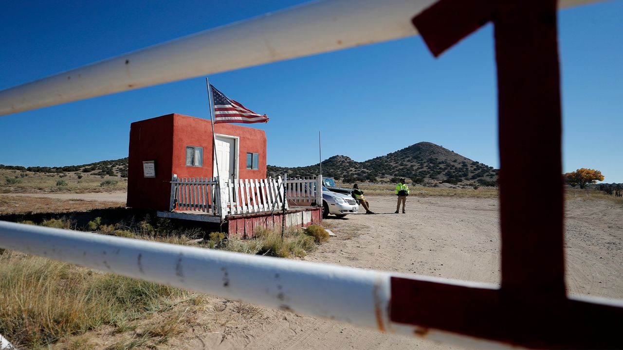 Private security stand at the entrance of the Bonanza Creek Film Ranch in Santa Fe, N.M., Friday, Oct. 22, 2021. Actor Alec Baldwin fired a prop gun on the set of a Western being filmed at the ranch on Thursday, Oct. 21, killing the cinematographer, officials said.(AP Photo/Andres Leighton)