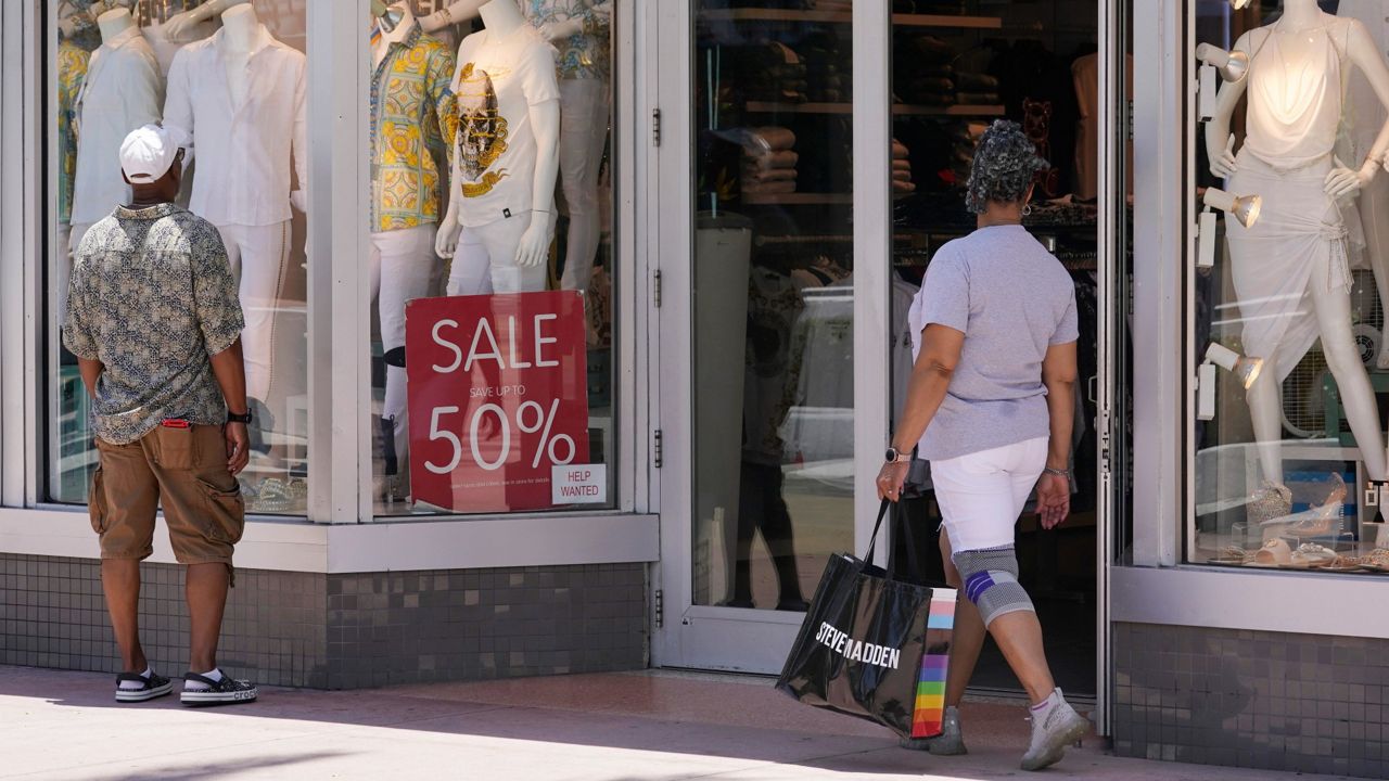 Shoppers look in a store window display Wednesday in Miami Beach, Fla. (AP Photo/Marta Lavandier, File)