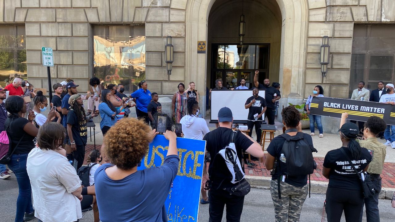 Rev. Raymond Greene Jr., executive director of the Freedom Bloc, addresses protesters outside an Akron City Council meeting. 